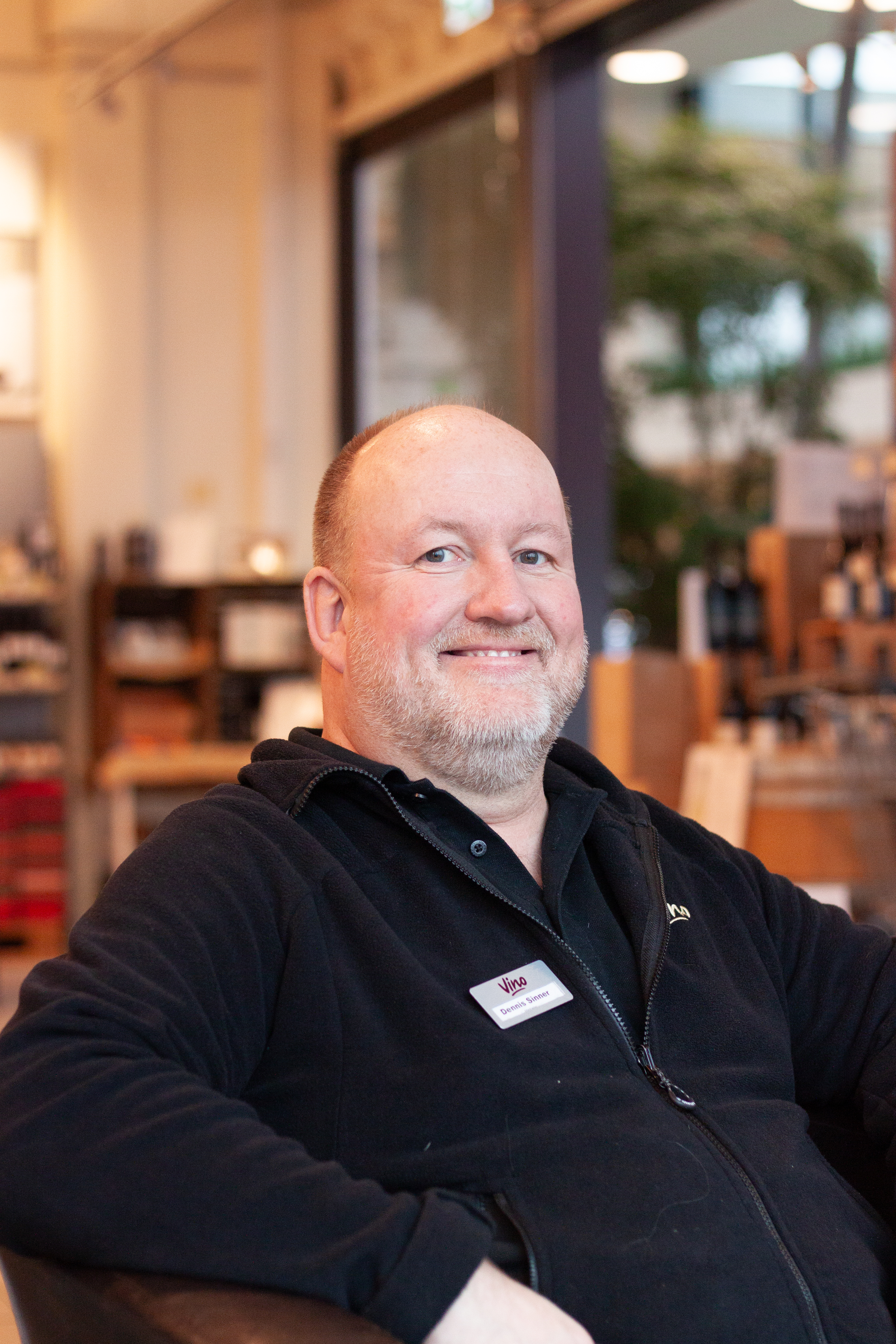 Weinexperte Dennis Sinner im Weinladen, lächelt freundlich