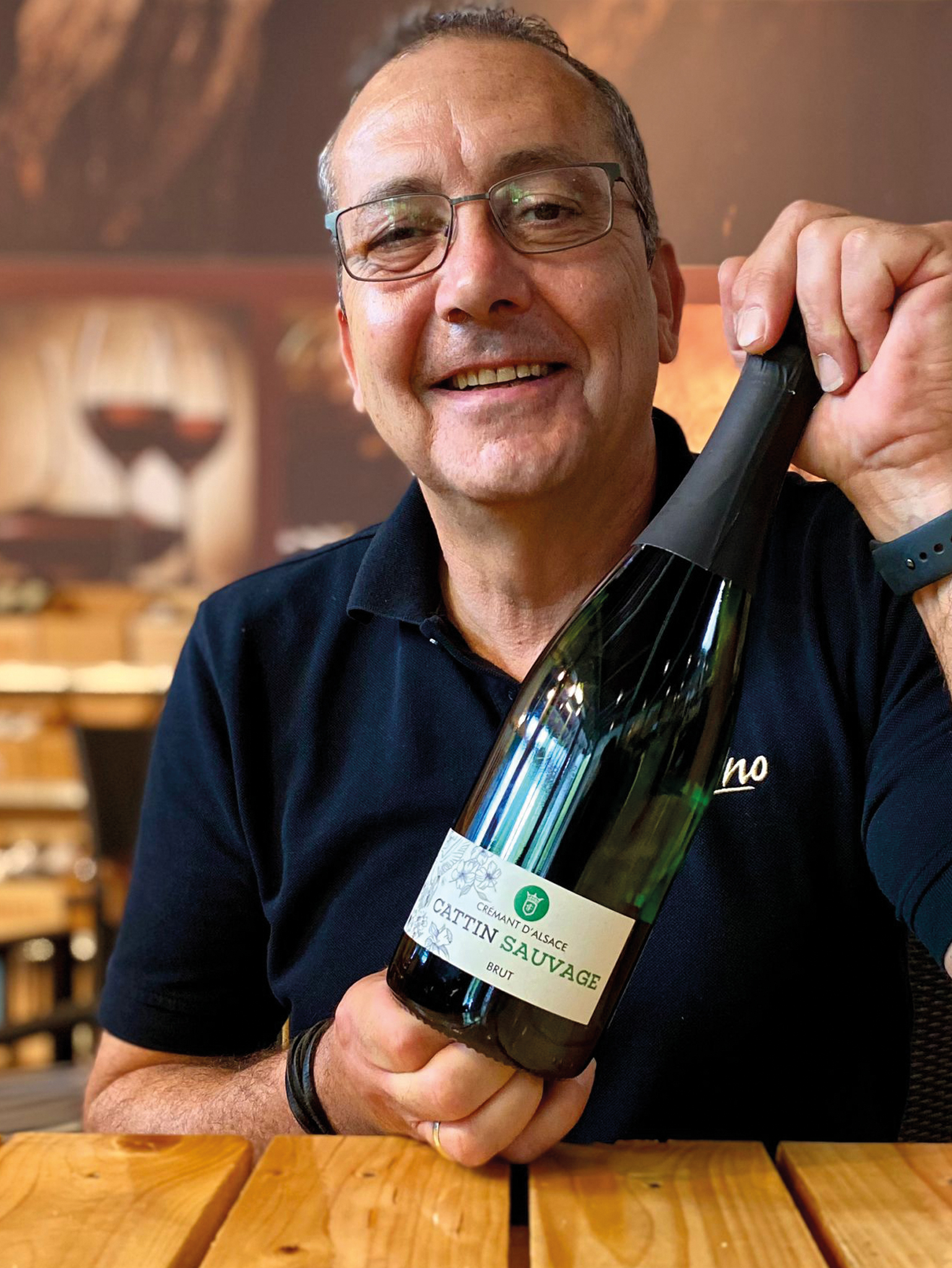 Mann präsentiert Cattin Crémant d’Alsace Brut, Wein Shop