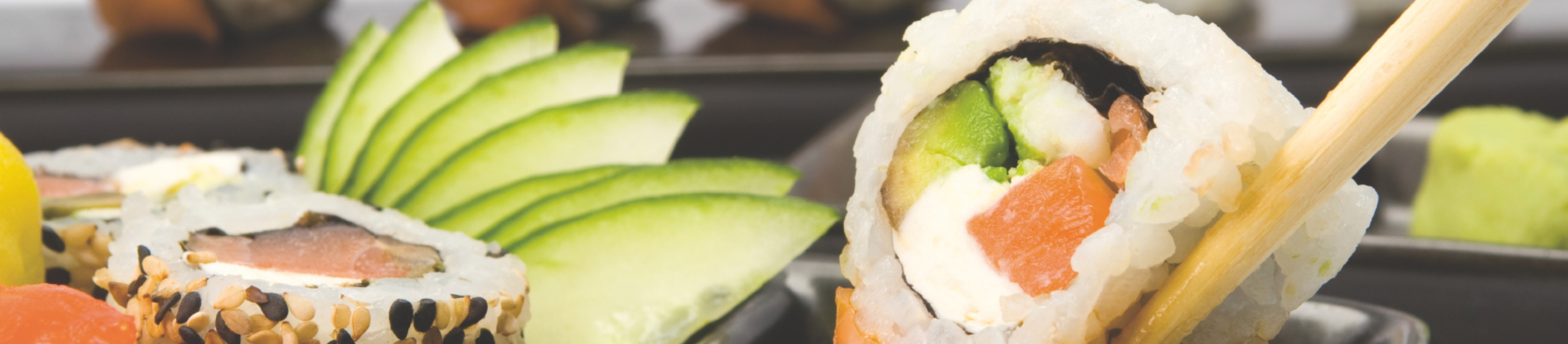 Sushi-Rolle mit Lachs, Gurke und Avocado, Stäbchen.