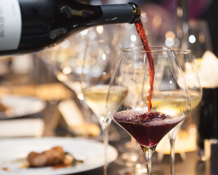 Rotwein wird in ein Glas gegossen, leckere Weine bestellen